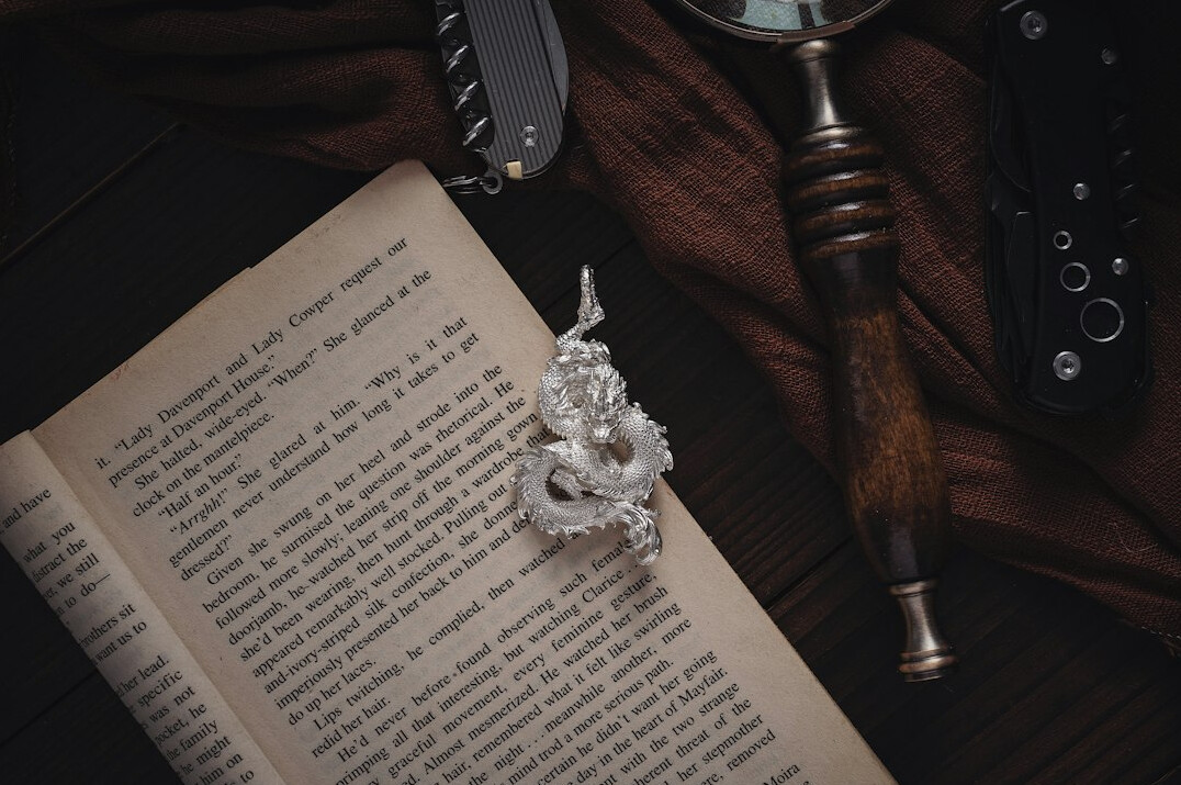 Hardcover investigative book with a magnifying glass on a wooden desk