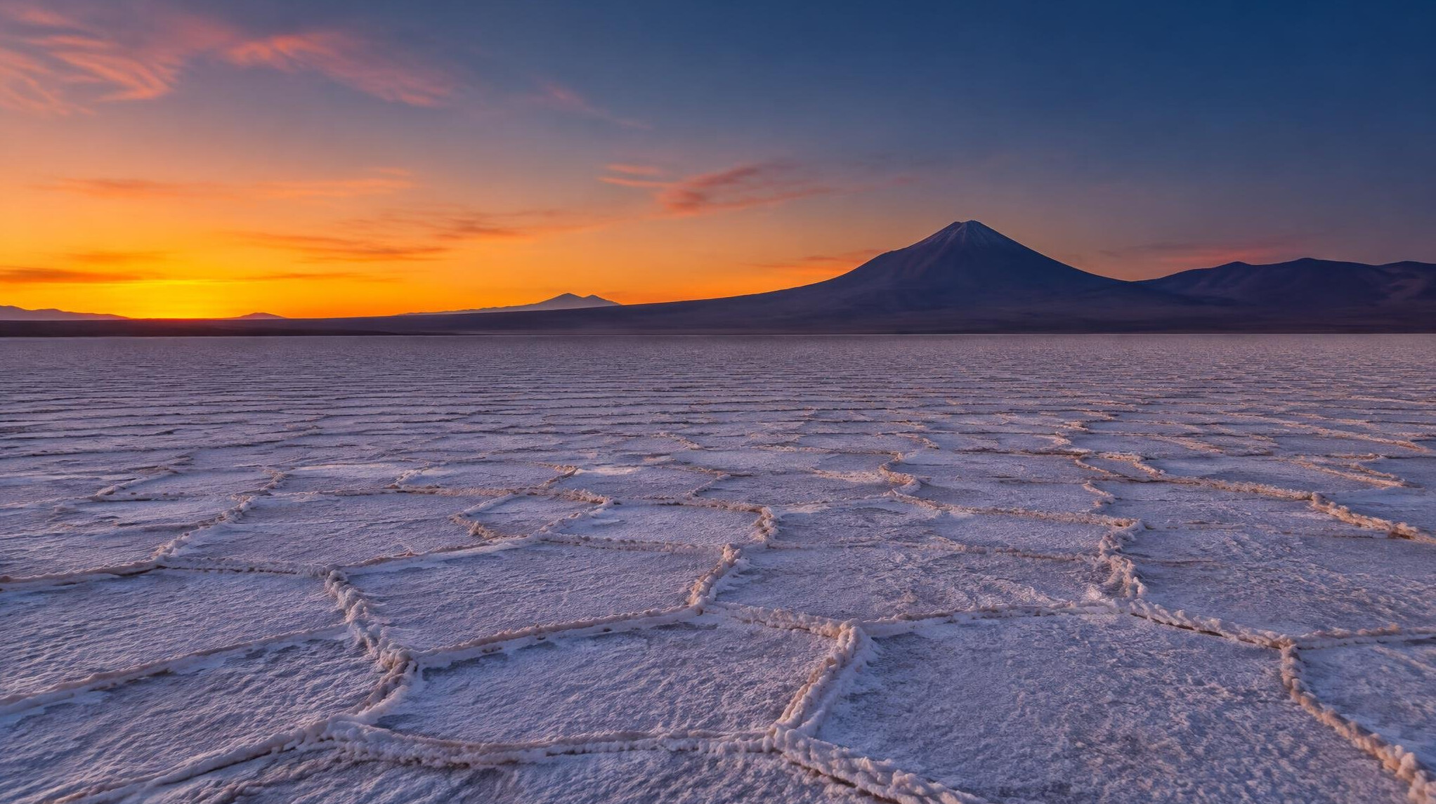 Atacama desert salt flat at dusk with distant volcano